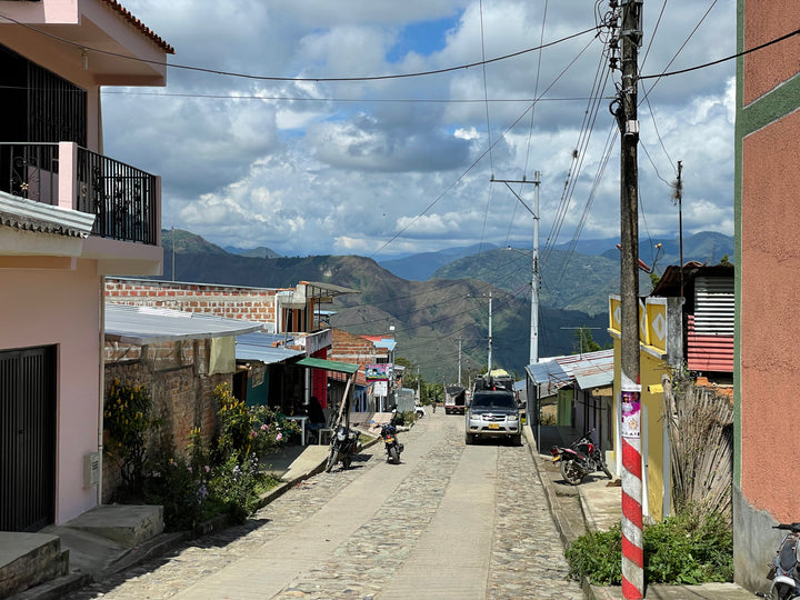 Street through a mountain town in Cauca, Colombia, with the coffee-growing hills behind it